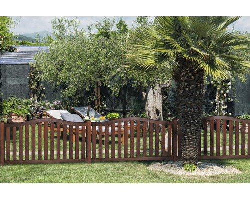 Scène de jardin avec clôture en bois, chaise longue et arbres