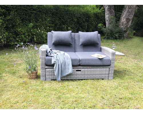 Gartenszene mit grauem Lounge Zweisitzer Sofa inklusive Kissen und Decke im Aussenbereich