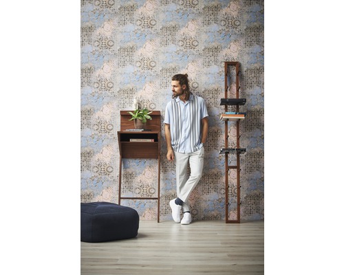 Wohnraum mit gemusterter Tapete, Stehpult, Regal und Sitzhocker