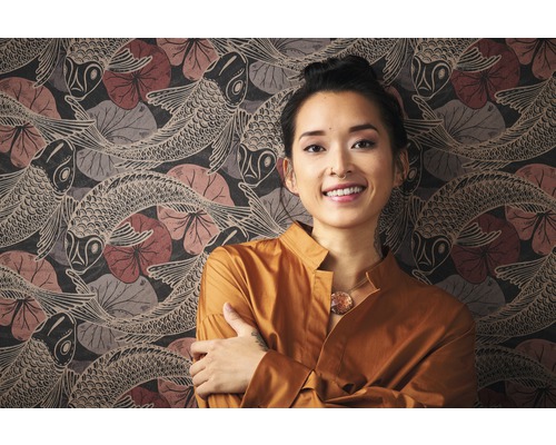 Frau vor einer Wand mit Tapete mit Fischmuster