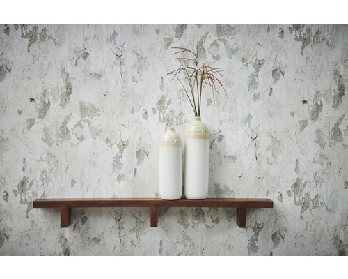 Vases décoratifs en céramique sur une étagère en bois devant un mur avec du papier peint usé