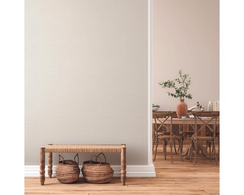 Salon avec papier peint textile, parquet, banc et coin repas en arrière-plan.