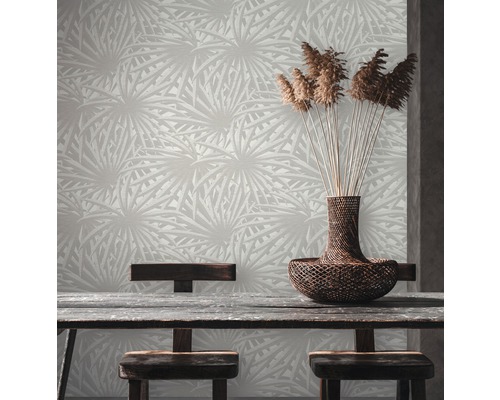 Une pièce avec un papier peint à motifs, une table en bois et un panier de plantes ornementales.