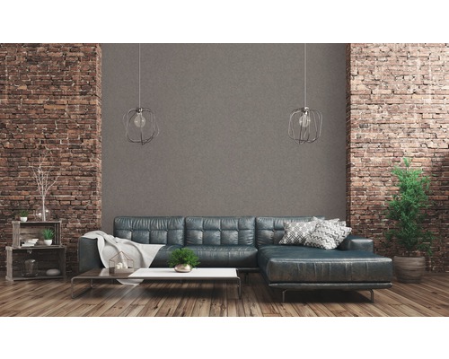 Wohnzimmer mit Sofa, Couchtisch und Dekoration vor einer Backsteinwand