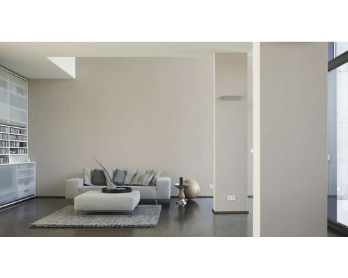 Salon lumineux avec canapé, tabouret, tapis et étagère