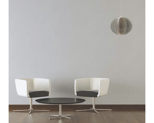 Salon avec deux fauteuils, une table et une suspension