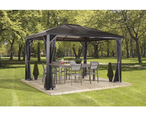 Pavillon avec table, chaises et rideaux dans le jardin