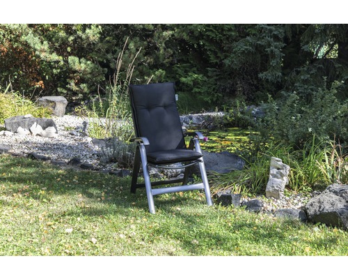 Chaise longue de jardin avec coussins dans le jardin