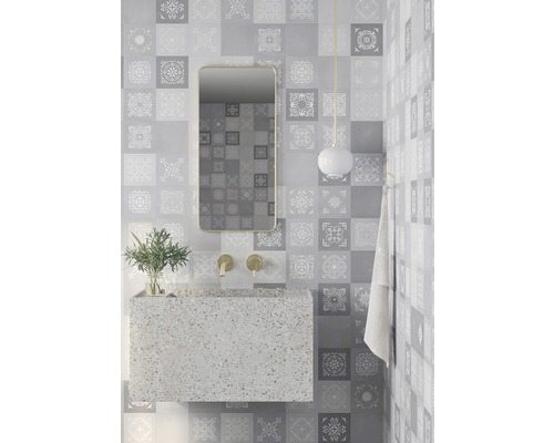 Badezimmer mit grauen Fliesen, Waschbecken, Spiegel und Lampe