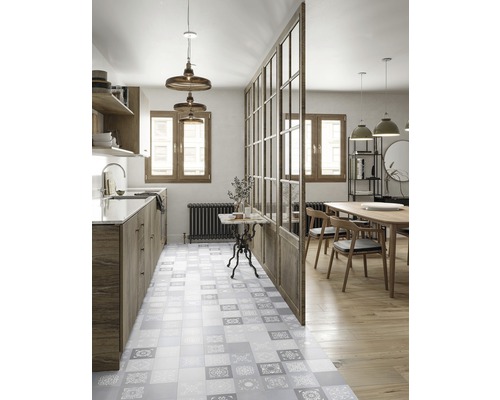 Helle Küche mit Fliesenboden im Patchwork-Design, Holzelementen und Glasabtrennung zum Essbereich.