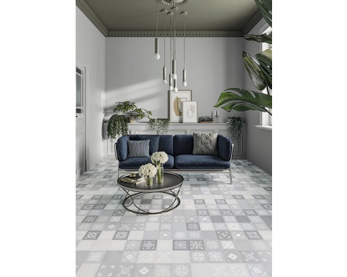 Helles Wohnzimmer mit Sofa, Couchtisch und gemusterten Fliesen.