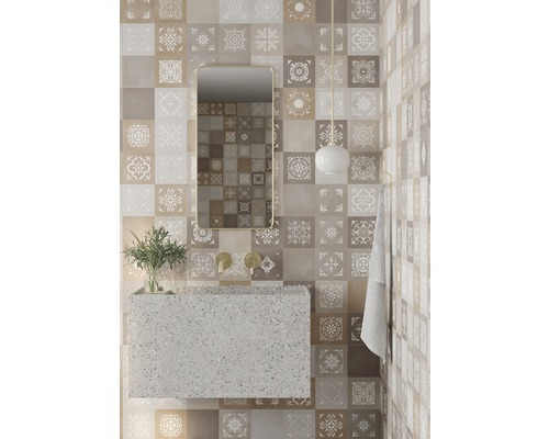 Salle de bain avec lavabo, miroir et carreaux muraux à motifs floraux.