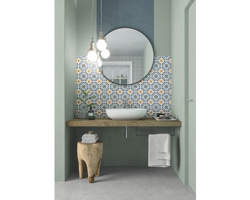 Salle de bains avec lavabo, miroir, carrelage à motifs et tabouret en bois