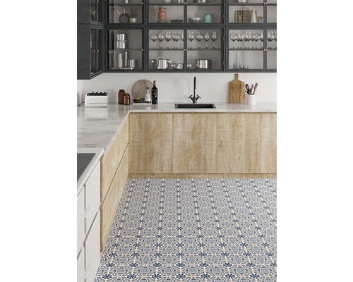 Küchenszene mit Spüle, Arbeitsplatte und gemusterten Bodenfliesen.