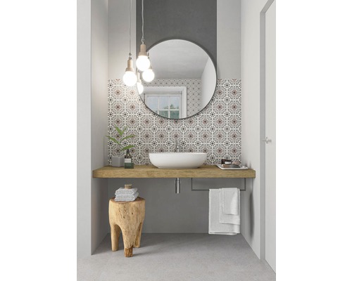 Salle de bains avec lavabo à poser, miroir, tabouret en bois et carreaux à motifs