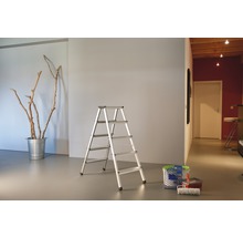 Vue d''une pièce avec un escabeau en aluminium, un seau avec des branches et du matériel de peinture