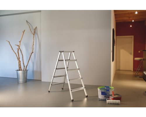 Vue d''une pièce avec un escabeau en aluminium, un seau avec des branches et du matériel de peinture