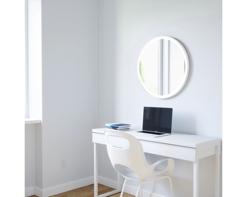 Helles Arbeitszimmer mit Schreibtisch, Stuhl, Laptop, Notizbüchern und einem runden Spiegel mit LED-Beleuchtung