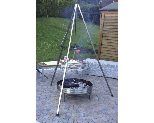 Szene mit Grillgalgen über einer Feuerstelle im Garten.