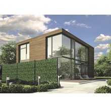 Maison moderne avec façade en verre et écran d''intimité en feuilles artificielles dans le jardin.