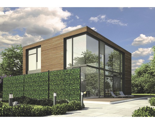 Maison moderne avec façade en verre et écran d''intimité en feuilles artificielles dans le jardin.