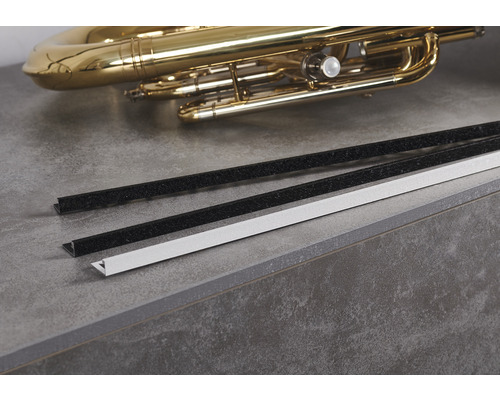 Des profilés en plastique et un tuba reposent sur un plan de travail.