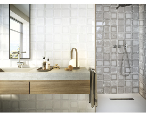 Badezimmer mit Waschbecken, Spiegel und Duschbereich mit quadratischen Fliesen