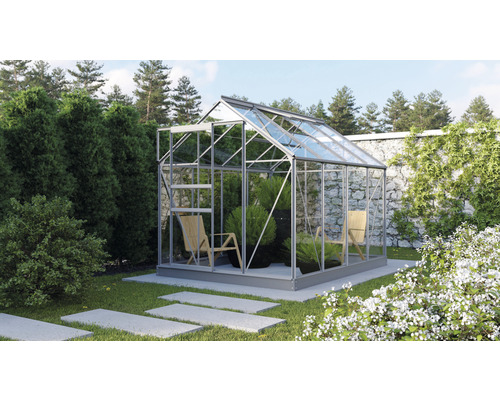 Une serre avec des plantes et des chaises dans un jardin.