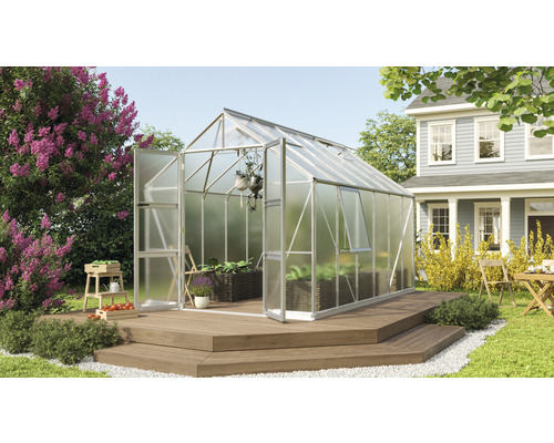 Gewächshaus Vitavia Olymp 9900 Hohlkammerplatten 4 mm 257 x 386 cm silber Gewächshaus mit geöffneter Tür auf einer Holzterrasse in einem Garten.