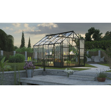 Gewächshaus mit Pflanzen und Gartenzubehör im Garten