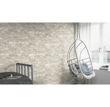 Pièce lumineuse avec mur de briques, fauteuil suspendu et lit