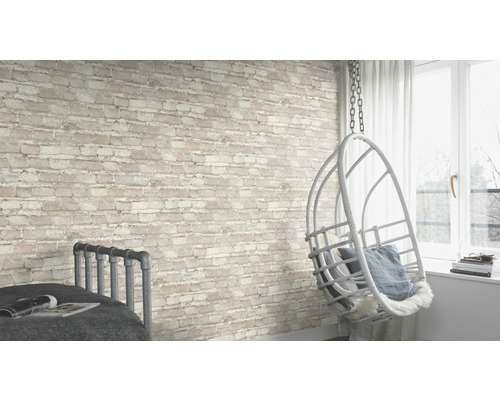 Pièce lumineuse avec mur de briques, fauteuil suspendu et lit