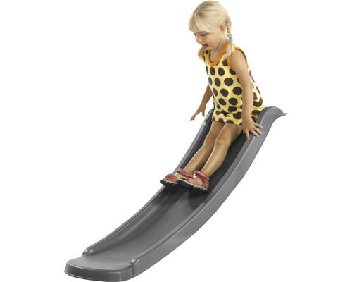 Un enfant glisse sur un toboggan gris.