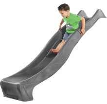 Garçon glissant sur un toboggan pour enfants gris