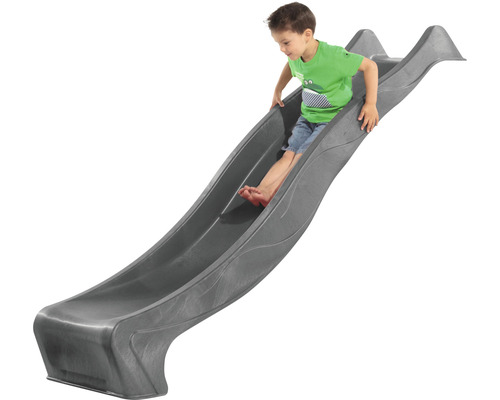Garçon glissant sur un toboggan pour enfants gris