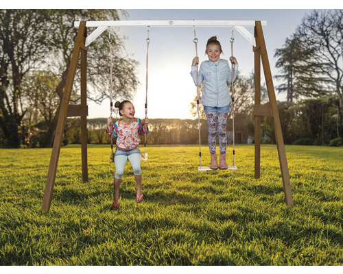 Balançoire en bois avec deux filles jouant dans le jardin