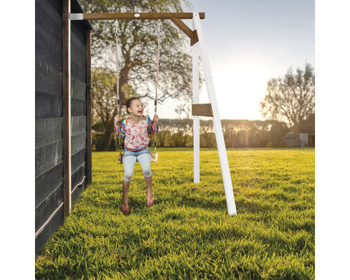 Fille se balançant sur une balançoire en bois dans le jardin