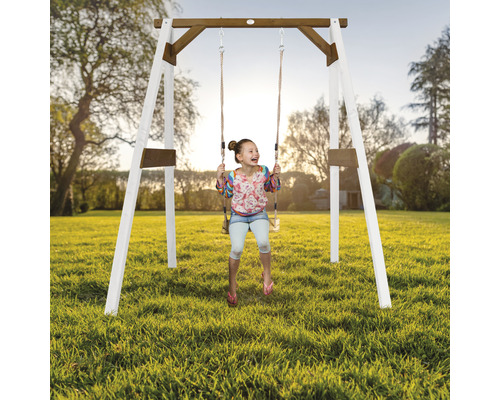 Enfant se balançant sur une balançoire en bois dans le jardin