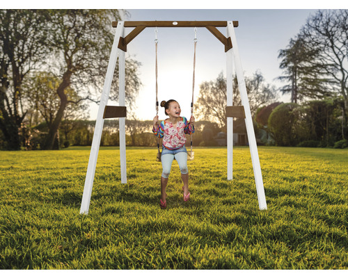 Fille se balançant sur une balançoire en bois dans le jardin