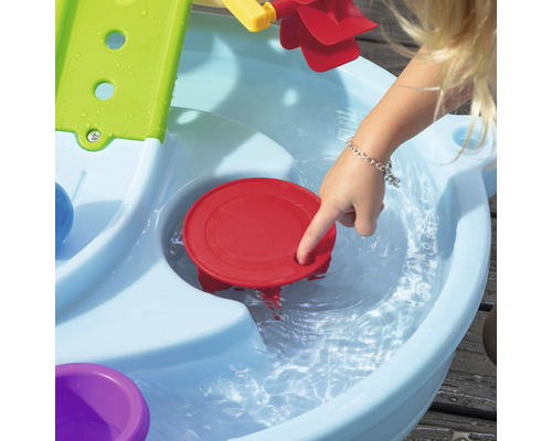 Enfant joue avec une table de jeu d''eau à l''extérieur