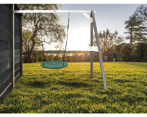Scène de jardin avec balançoire ronde fixée sur une armature en bois