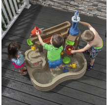 Des enfants jouent avec une table d''eau Step2 à l''extérieur avec pompe à eau et toboggan aquatique.