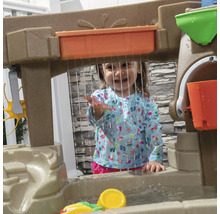 Enfant joue avec une table d''eau à l''extérieur