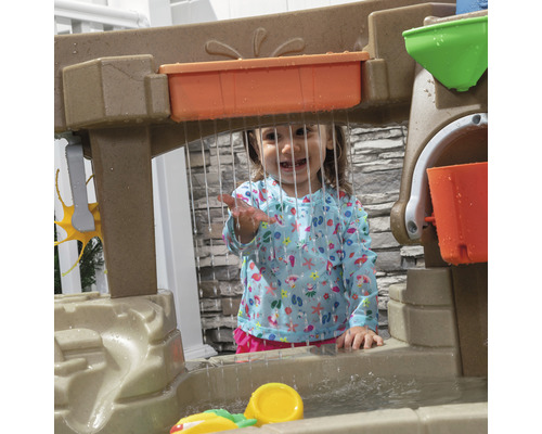 Enfant joue avec une table d''eau à l''extérieur