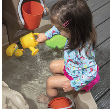 Fille jouant avec une table de jeu d''eau et un arrosoir jaune