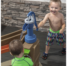 Des enfants jouent avec une pompe à eau sur une table à sable et à eau