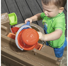 Enfant jouant avec une table d''eau à l''extérieur