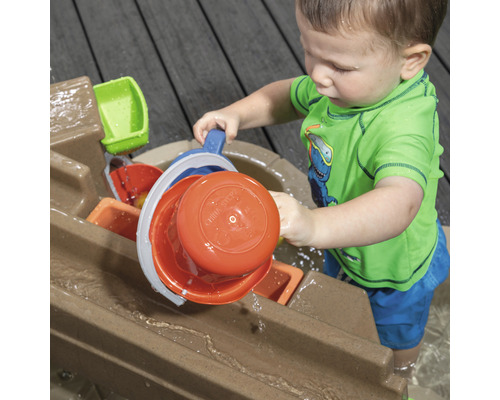 Enfant jouant avec une table d''eau à l''extérieur