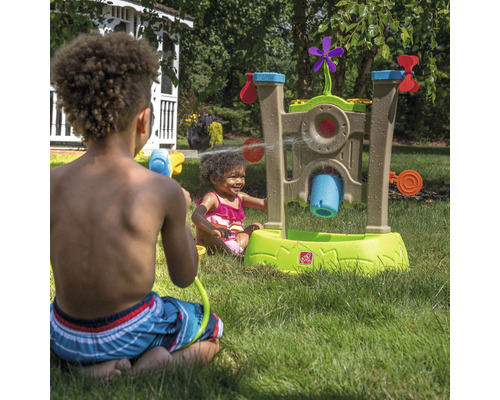 Des enfants jouent avec une table d''eau Step2 dans le jardin