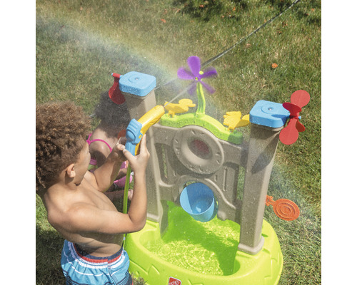 Table de jeu d''eau avec accessoires dans le jardin avec des enfants qui jouent